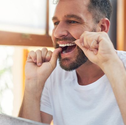 Closeup of man smiling while flossing