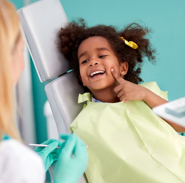 Child in dental chair smiling