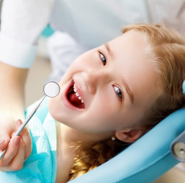 Child receiving an exam during their first visit to the dentist