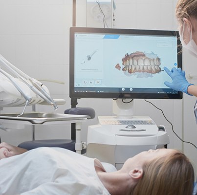 a dentist showing a patient a model of their mouth