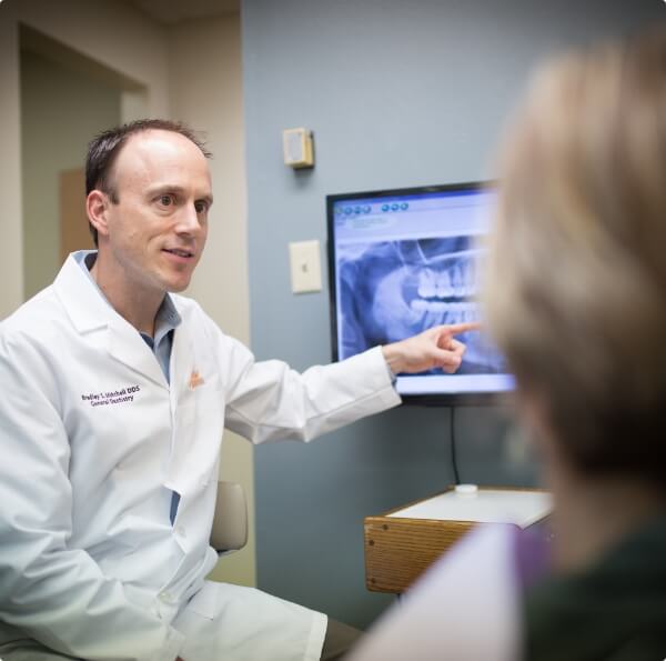 cosmetic dentist and dental patient discussing treatment plans