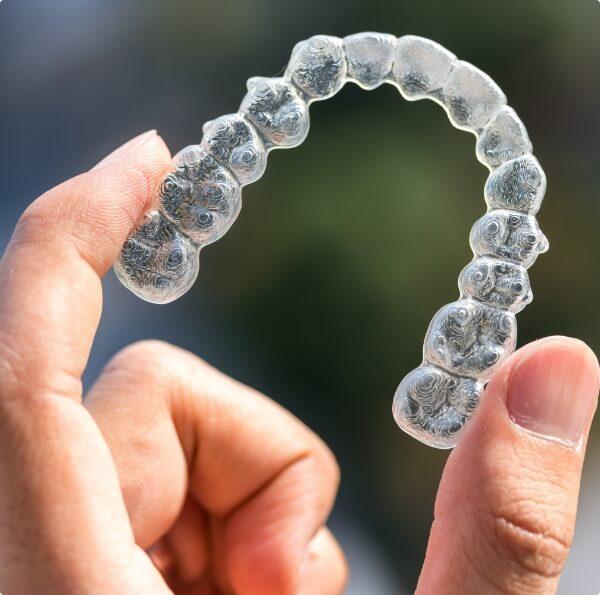 Person holding an Invisalign tray