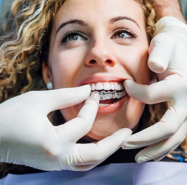 Dentist fitting dental patient's Invisalign tray