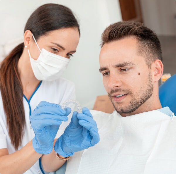 Dental patient and dentistry team member looking at Invisalign tray