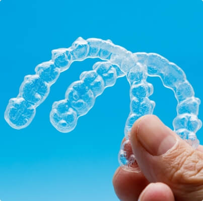 Hand holding two Invisalign trays
