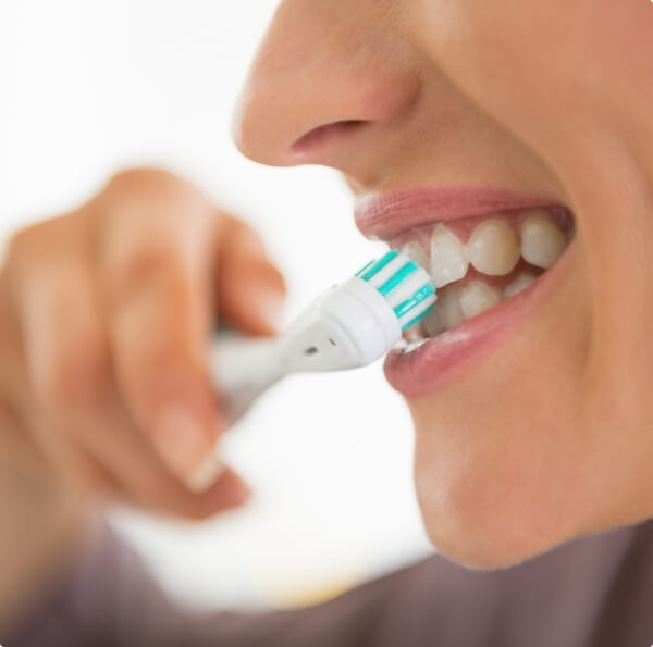 Person brushing teeth to keep smile healthy