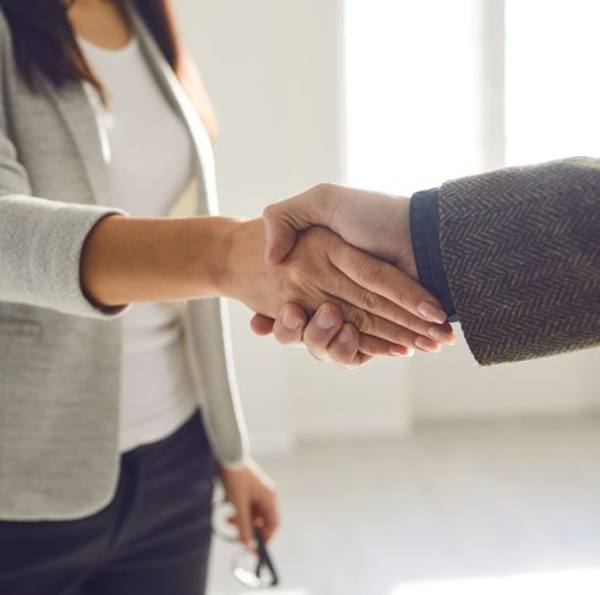 Two people shaking hands in professional setting