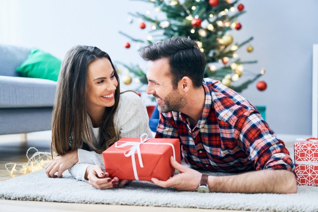 Couple exchanging Christmas presents at home