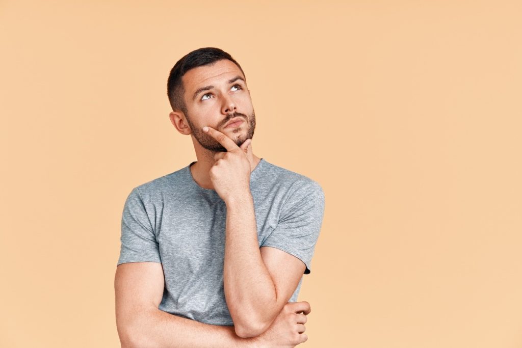 Closeup of man wondering about veneers and Invisalign