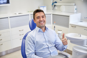 Male dental patient giving a thumbs up